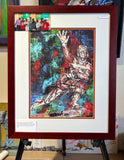 Framed artwork of the Heisman Trophy with a colorful abstract background on an easel.